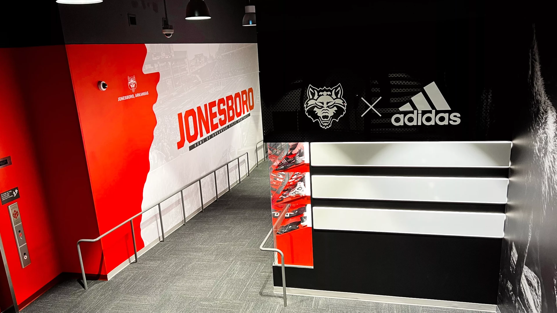 Jonesboro wall graphic in the corridor with gear display and wolf wall graphic.